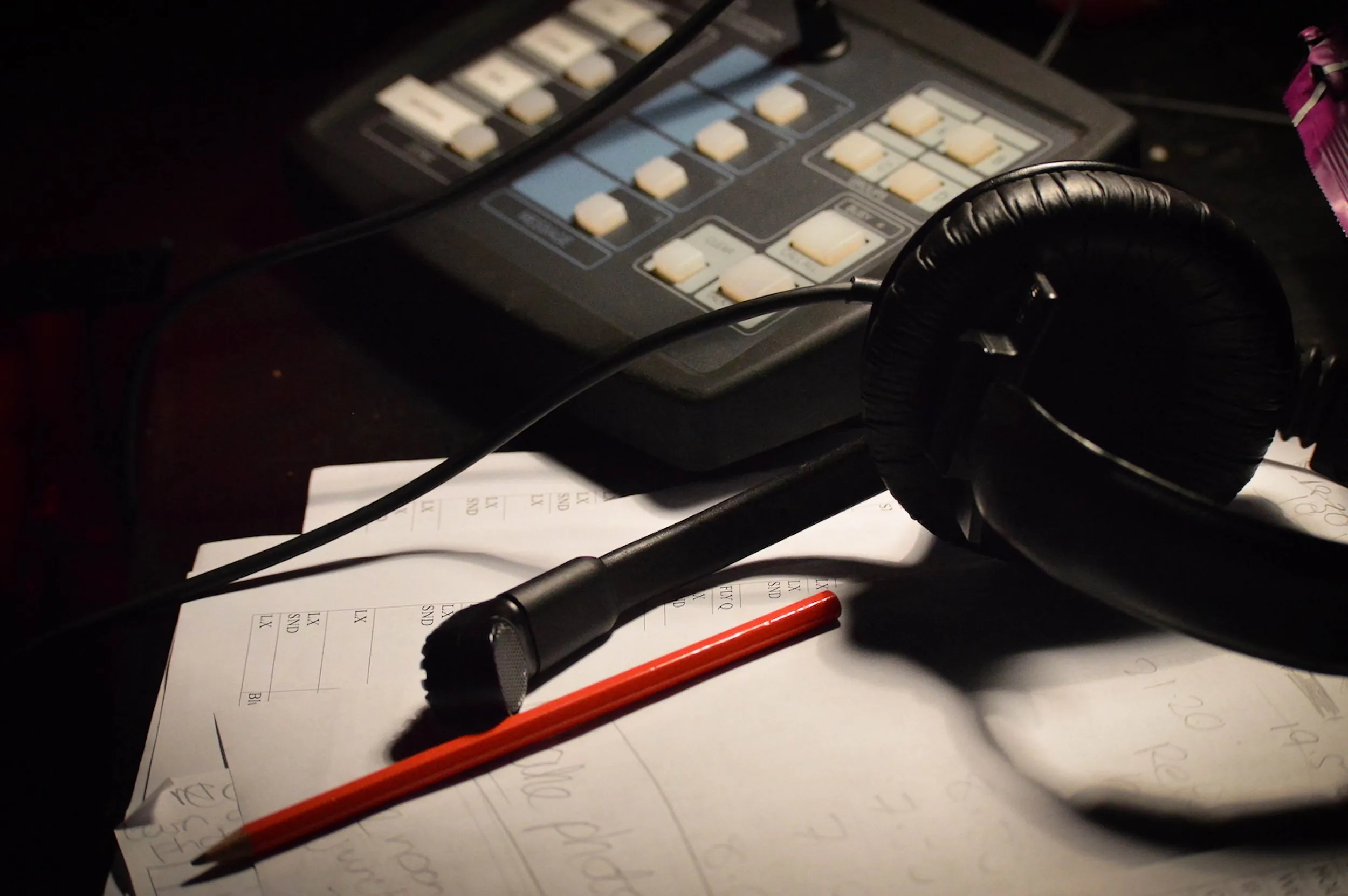 Stage manager's desk with headset, cue light controller, red pencil and marked-up cue sheets